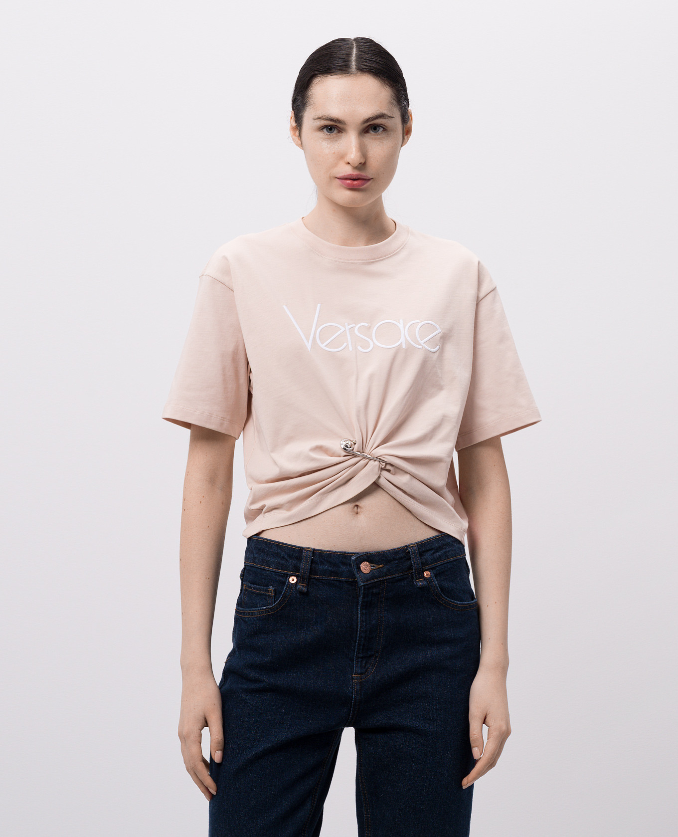 

Beige cropped T-shirt with logo and branded pin Versace