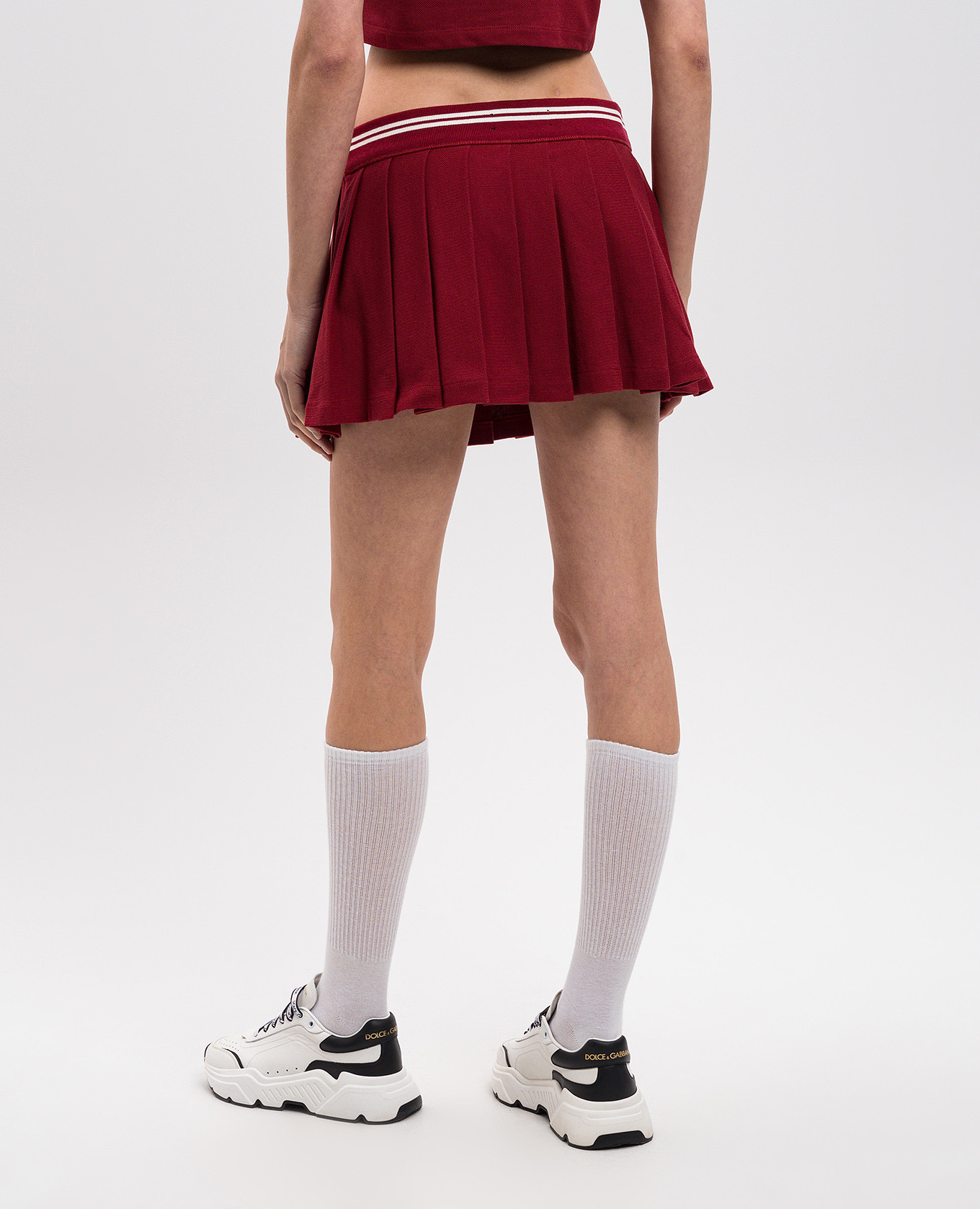 

Burgundy pleated mini skirt with embroidered emblem AMIRI