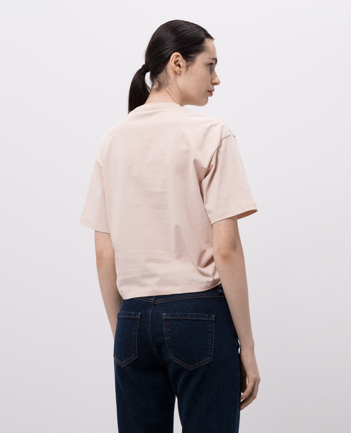 

Beige cropped T-shirt with logo and branded pin Versace