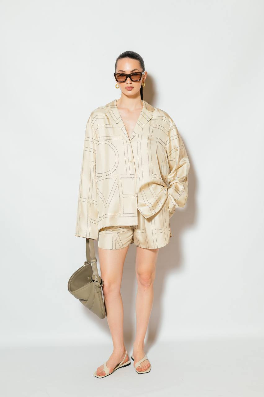

Beige silk shorts with embroidered monogram logo Toteme