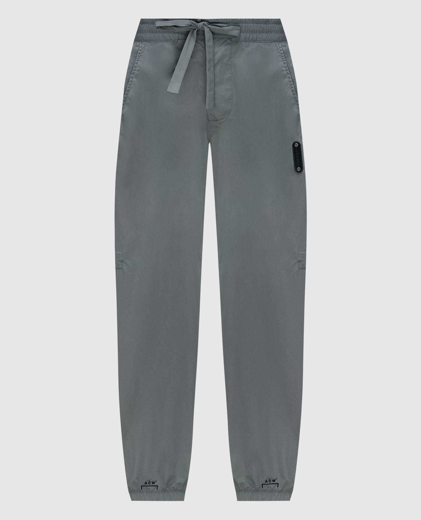 Gray joggers with logo patch a cold wall
